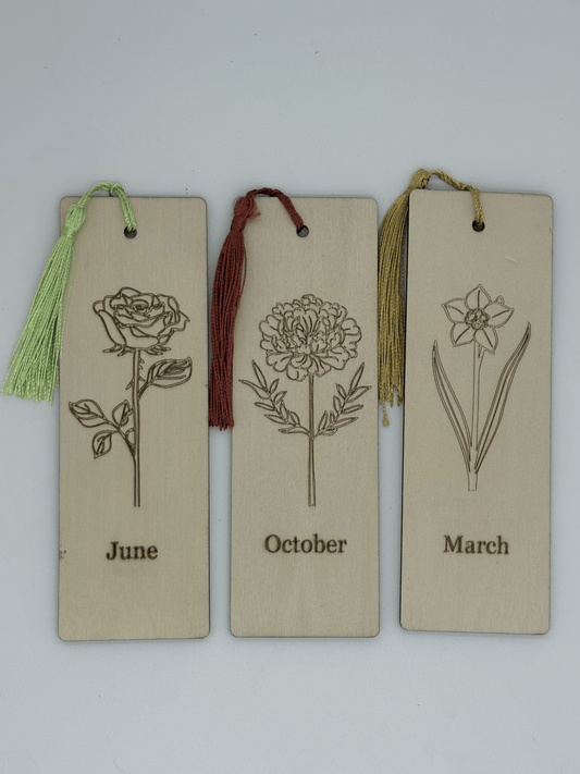 Three bookmarks with floral illustrations and months engraved, each with a tassel.